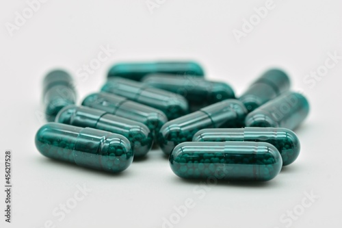 Forma farmacéutica de cápsulas verdes, aislado sobre fondo blanco photo