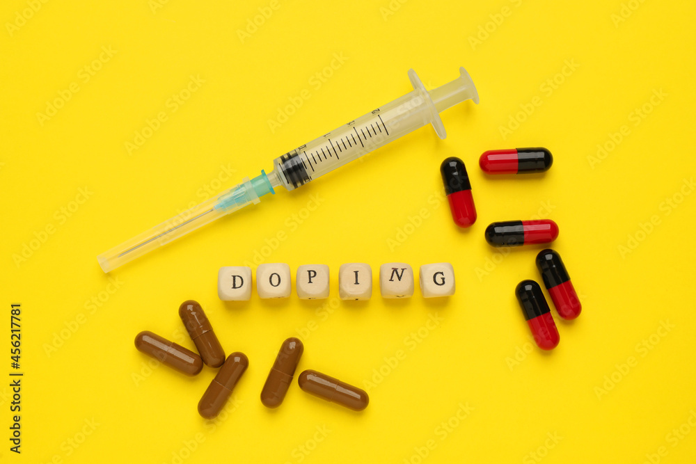 Wooden cubes with word Doping and drugs on yellow background, flat lay Wooden cubes with word Doping and drugs on yellow background, flat lay