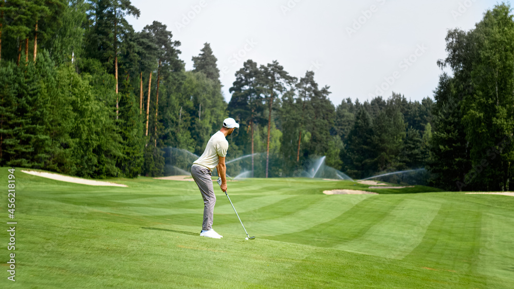 Fototapeta premium Young golfer playing golf outdoors