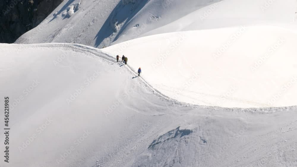 alpinists climbing mountain in good sunny conditions