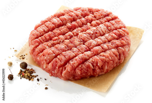 Raw hamburger patty isolated on white