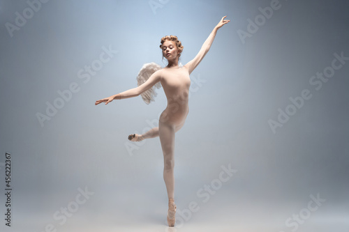 Young and graceful ballet dancer, ballerina dancing isolated on white gray studio background. Art, motion, action, flexibility, inspiration concept.