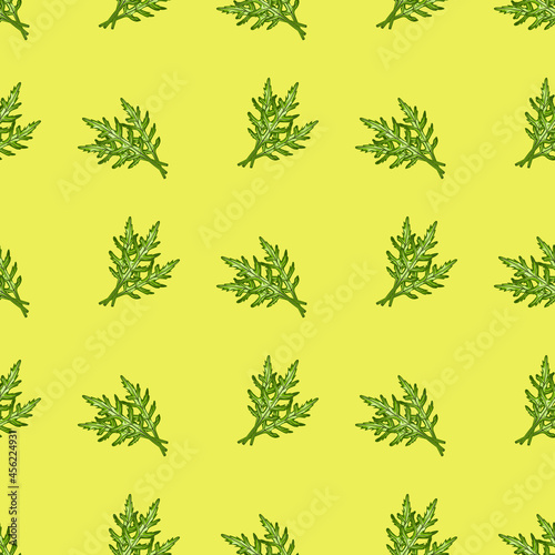 Seamless pattern bunch arugula salad on yellow background. Simple ornament with lettuce.