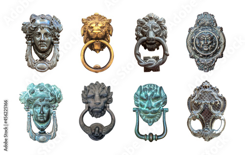 Set of isolated door knockers, gold lion head with the ring on its mouth, antique head and italian traditional doorknobs on white background.  Old ornate metal door handle on the entrance of a house.