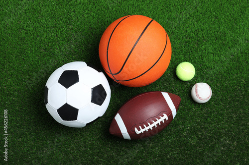 Set of different sport balls on green grass  flat lay