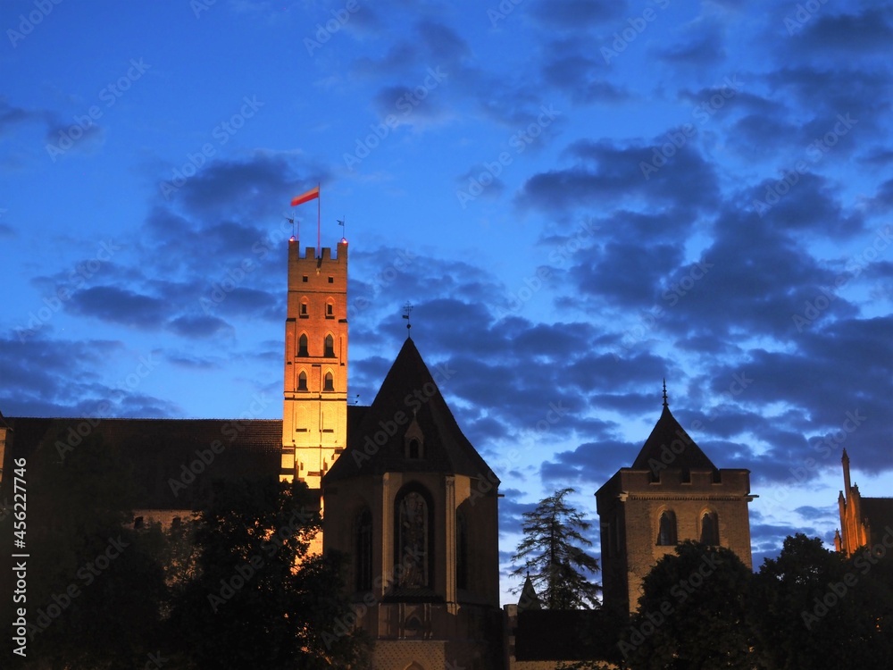 The towers of Malbork Castle against the twilight sky