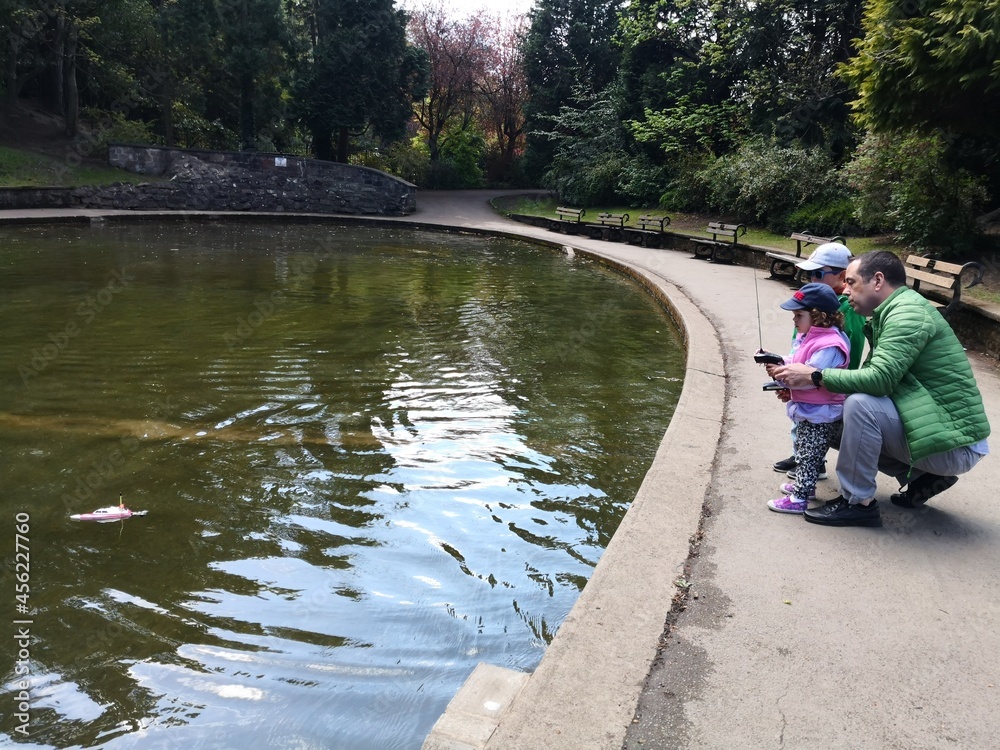 Father and kids at the boating lake in Valley Gardens, Harrogate, UK Father and kids at the boating lake in Valley Gardens, Harrogate, UK
