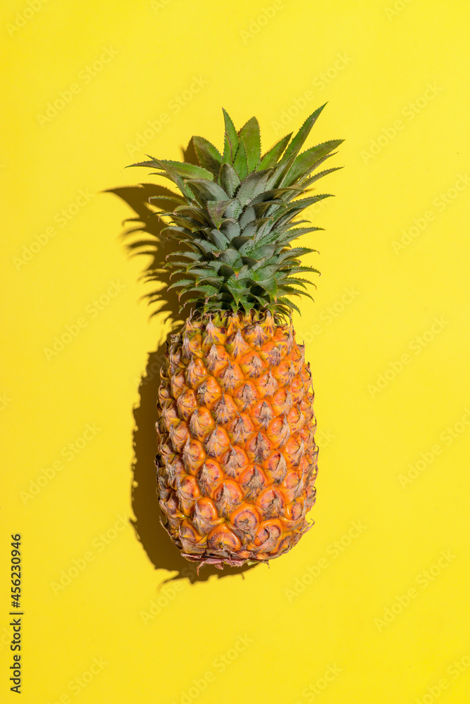 Summer fruit. Pineapple on bright yellow background.