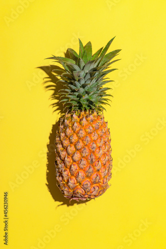 Summer fruit. Pineapple on bright yellow background.
