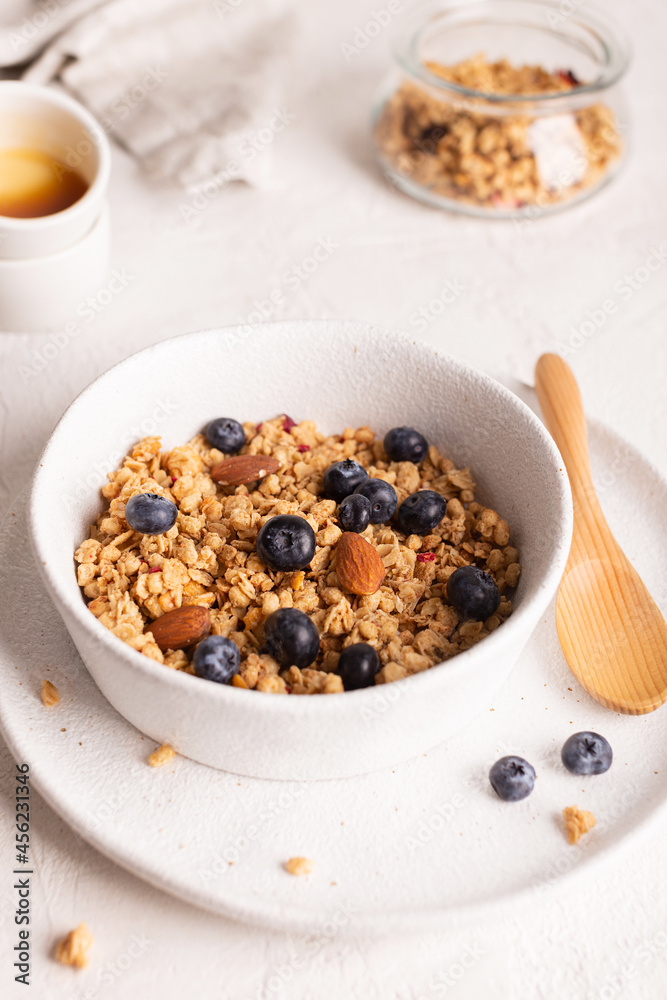 Healthy breakfast with crunchy granola with blueberries in a white bowl Healthy breakfast with crunchy granola with blueberries in a white bowl