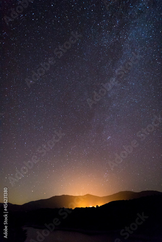 Milky Way starry night sky over hills and trees Sardinia Italy