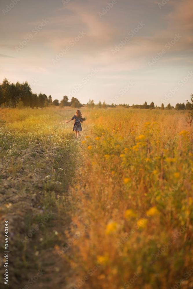 a yellow field and a running child