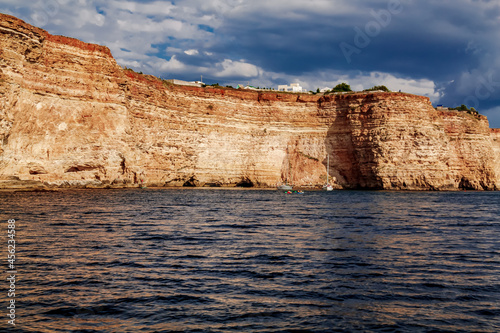 Black Sea red rocks coastline. Coastal red rocks and blue sea. Seascape. Summer. Traveling.