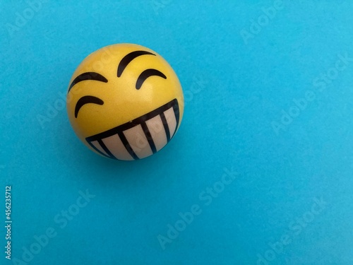 Pelota happy face amarillo sobre fondo azul