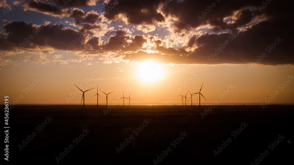 Aerial view of wind power plant on sunset. sea background. 4k drone image. Aerial view of wind power plant on sunset. sea background. 4k drone image.