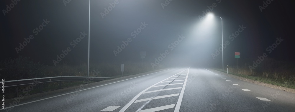 Panoramic view of the illuminated new highway in a fog at night, street  lights close-up. Moonlight. Dark urban scene. Europe. Transportation,  logistics, travel, tourism, road trip, freedom, driving Stock Photo | Adobe