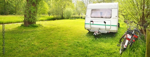 Foto White caravan trailer on a green lawn in a camping site