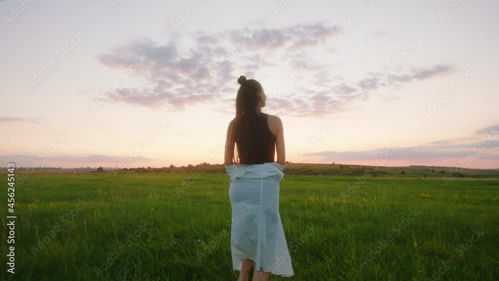 Beautiful tall lady in front of the camera At sunset enjoy the moment walking through the green field Beautiful tall lady in front of the camera At sunset enjoy the moment walking through the green field