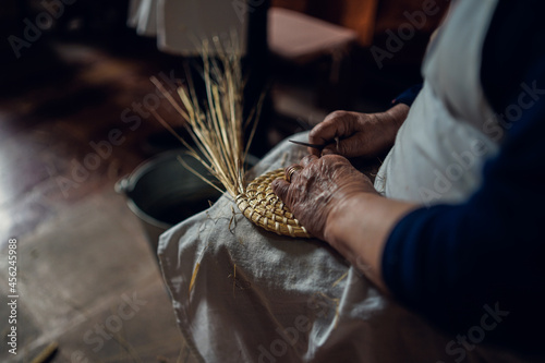 Obraz na płótnie hands of an elderly woman working on ears of straws w salonie