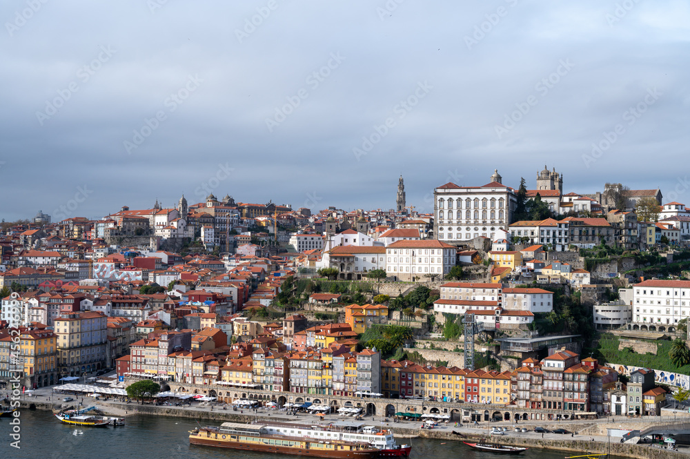 Fototapeta premium Porto, Portugal, October 31,2020. View on colorful old houses on hill in old part of city and embankment of Douro river in rainy day
