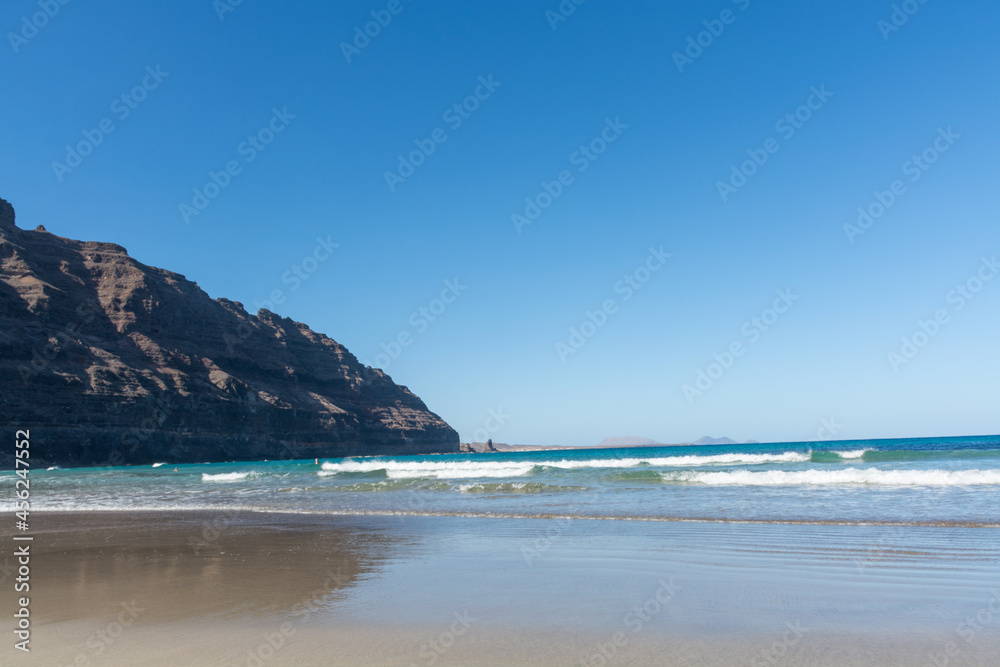 Black lava rocks and water waves of Atlantic ocean, nature landscape on Lanzarote, Canary islands, Spain