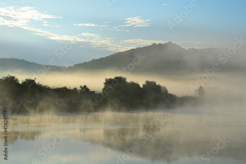 Misty lake in the hills at summer dawn. Arló, Hungary. © Tamas