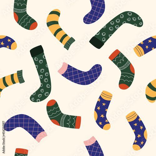 Seamless pattern with different designs of socks on a beige background. Vector illustration flat for wrapping paper or print.