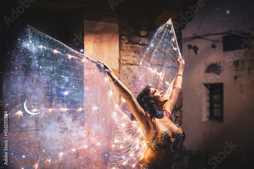 Belly dancer with starry wings and gold dress photo