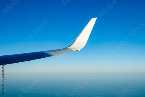 Plain wing over blue sky. Flight from Amsterdam to Helsinki.