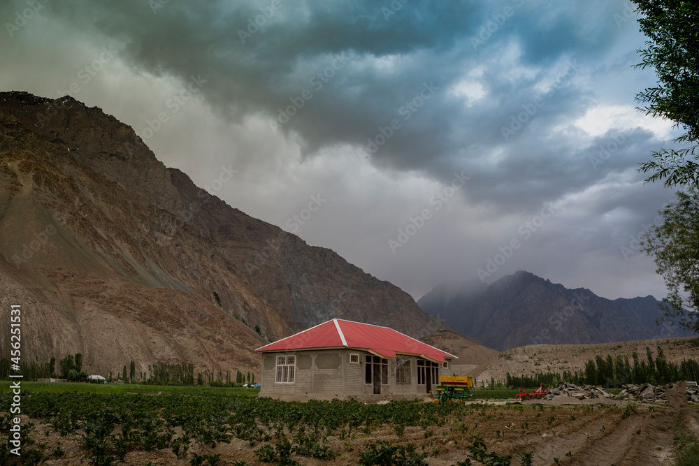 house in the mountains with clouds just before rain.