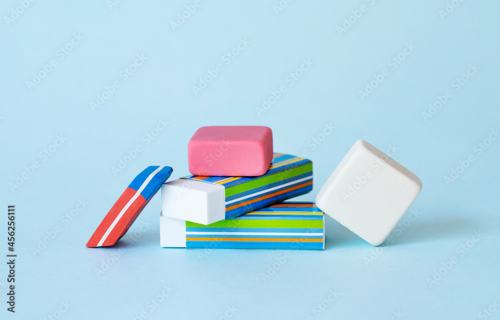 Pile of erasers on light blue background. Pile of erasers on light blue background.