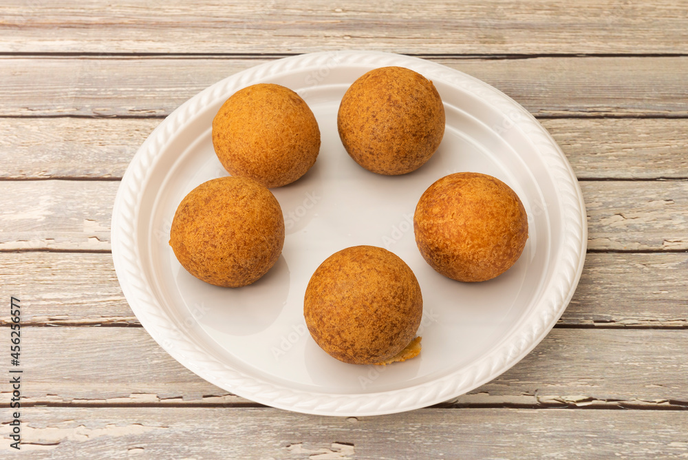 Colombian corn flour fritters on white plastic plate Colombian corn flour fritters on white plastic plate