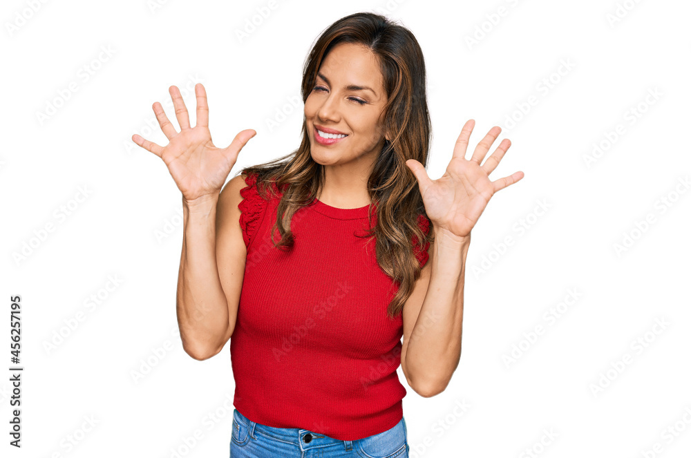 Young hispanic woman wearing casual clothes showing and pointing up with fingers number ten while smiling confident and happy. Young hispanic woman wearing casual clothes showing and pointing up with fingers number ten while smiling confident and happy.