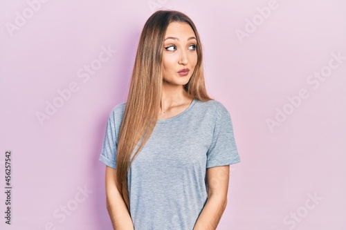Young blonde girl wearing casual t shirt smiling looking to the side and staring away thinking. © Krakenimages.com