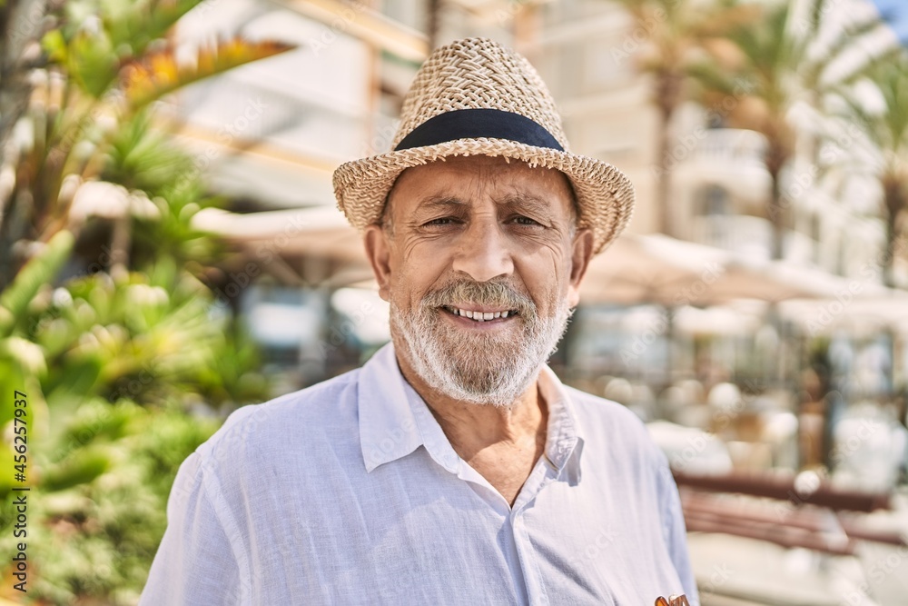 Senior man smiling confident wearing summer hat at street