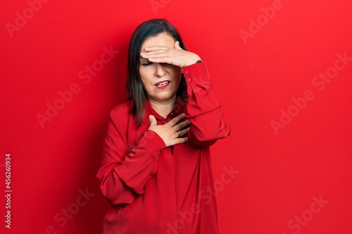 Middle age hispanic woman wearing casual clothes touching forehead for illness and fever, flu and cold, virus sick