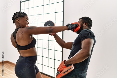 Young african american sporty couple boxing at sport center.