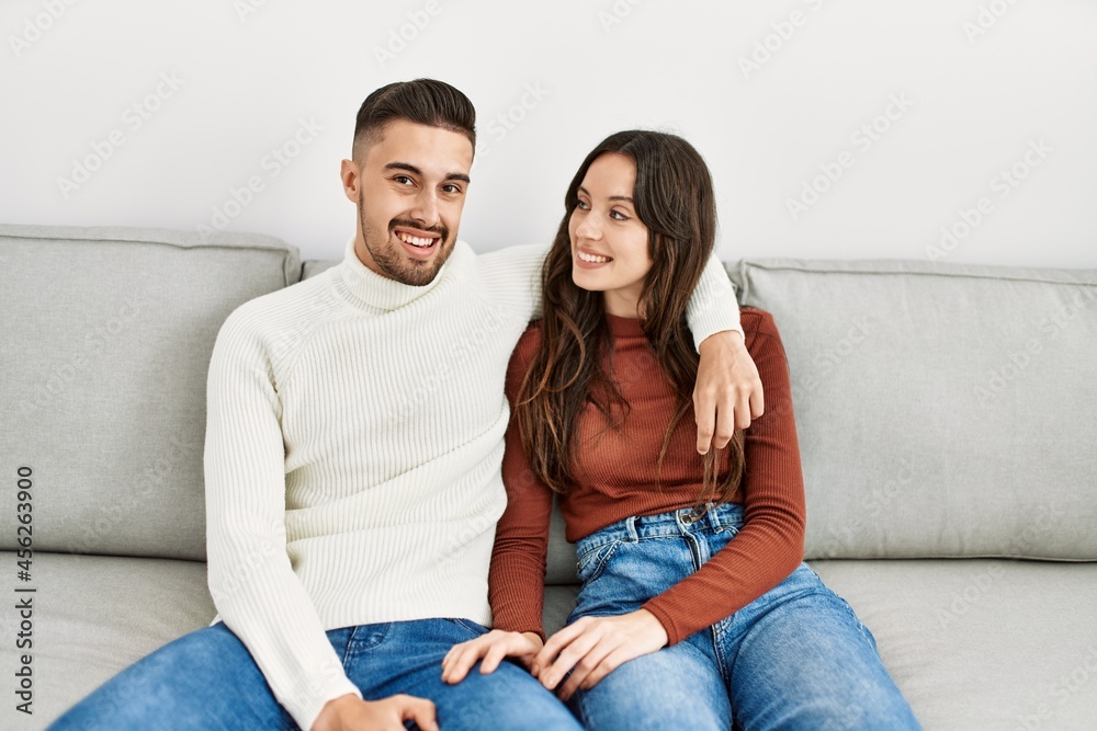 Young hispanic couple sitting on the sofa and hugging at home. Young hispanic couple sitting on the sofa and hugging at home.