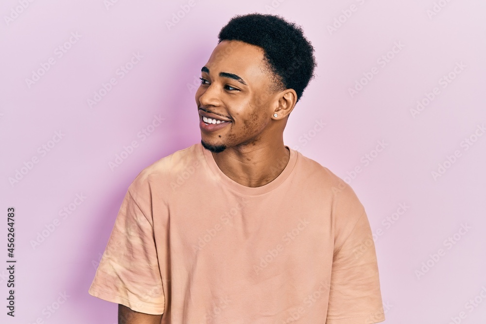 Young african american man wearing casual t shirt stressed and frustrated with hand on head, surprised and angry face Young african american man wearing casual t shirt stressed and frustrated with hand on head, surprised and angry face