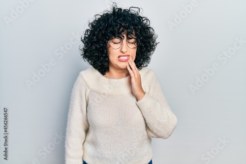 Young middle east woman wearing casual white tshirt touching mouth with hand with painful expression because of toothache or dental illness on teeth. dentist