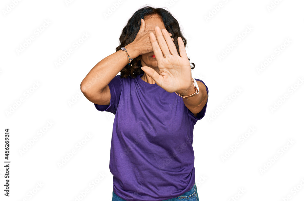 Middle age hispanic woman wearing casual clothes covering eyes with hands and doing stop gesture with sad and fear expression. embarrassed and negative concept. Middle age hispanic woman wearing casual clothes covering eyes with hands and doing stop gesture with sad and fear expression. embarrassed and negative concept.