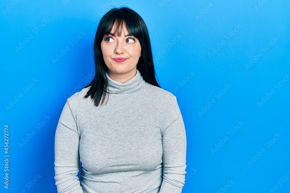 Young hispanic woman wearing casual clothes smiling looking to the side and staring away thinking. Young hispanic woman wearing casual clothes smiling looking to the side and staring away thinking.