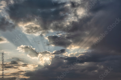 Sunbeams piercing the clouds at dawn.
