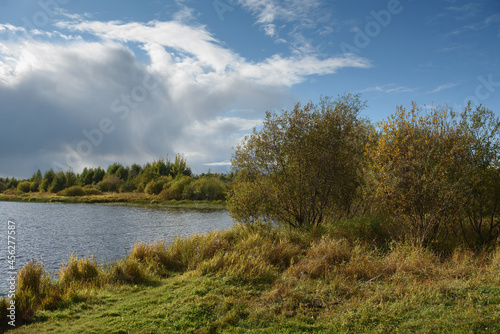 A picturesque river bank in early autumn with grass on the bank
