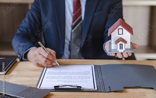 Businessman signing signature loan document to homeownership. Mortgage and real estate property investment, home insurance, security, Man  signing contract insurance, Real estate concept