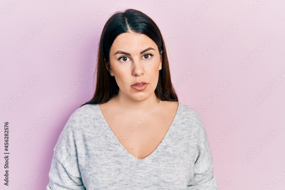 Young hispanic woman wearing casual clothes relaxed with serious expression on face. simple and natural looking at the camera.