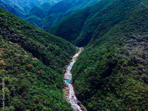 Fototapeta Naklejka Na Ścianę i Meble -  aerial view of a river passing between mountain and forest