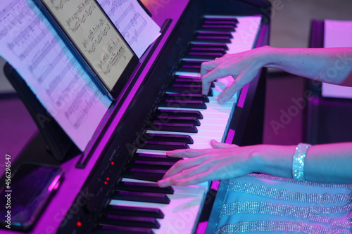the hands of a musician play the piano