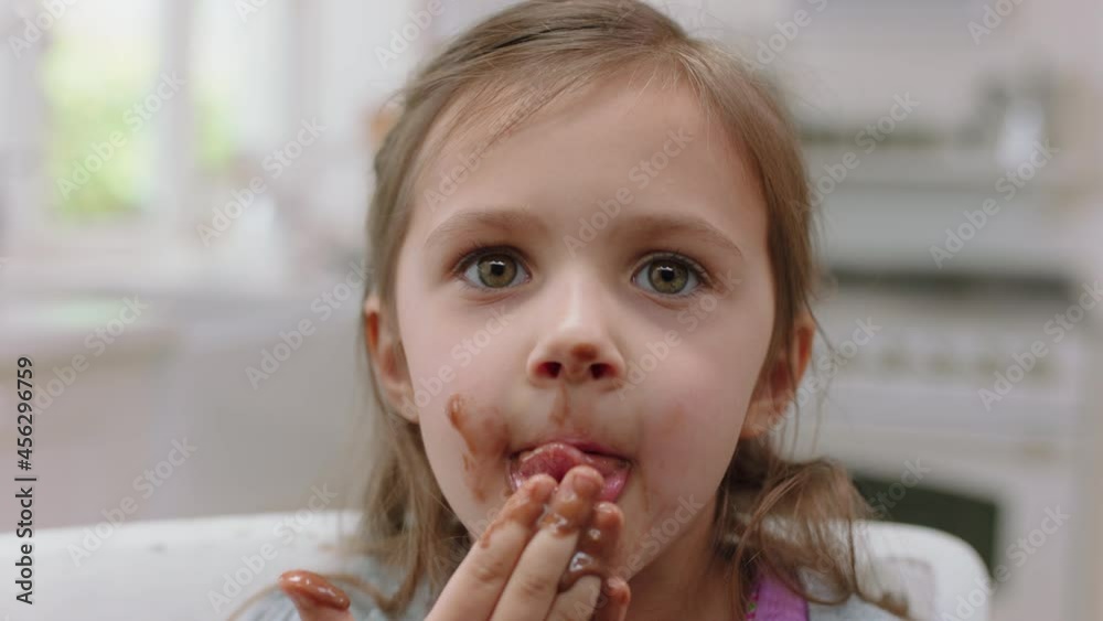 cute little girl with hands covered in chocolate licking fingers having fun baking in kitchen naughty child enjoying tasty treat at home cute little girl with hands covered in chocolate licking fingers having fun baking in kitchen naughty child enjoying tasty treat at home