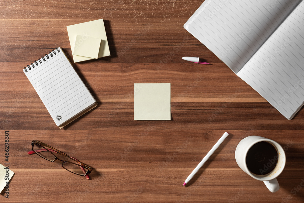 Top view of blank notes and office supplies with smartphone, iphone, glasses, pen, cup of coffee Top view of blank notes and office supplies with smartphone, iphone, glasses, pen, cup of coffee